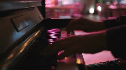 hands of musician playing keyboard in concert in night club - Powered by Adobe