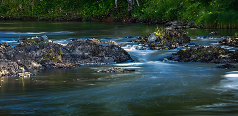 Rocky river Bank with mixed forest.