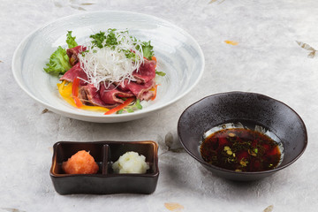 Sliced medium rare wagyu topping with sliced radish and scallion served with mince radish, carrot and Ponzu sauce on washi (Japanese paper).