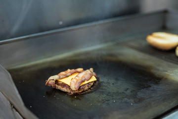 Preparation of a delicious juicy burger close-up. All the ingredients are made on the grill