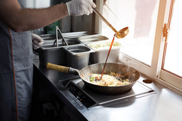 The process of making Chinese noodles close-up. Noodles are cooked in a special wok