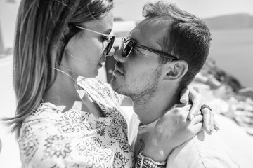 Black&white photo of a young couple with a view to the sea, they look each other in the eye