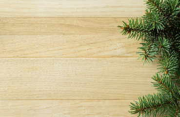 Christmas and New Year background. Branches of spruce on the background of natural wood. Selective focus. Horizontal.