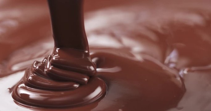 Slow motion pouring dark melted chocolate