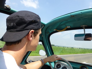 Young man driving heinkel cabin (vintage car) in turquoise 3