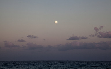 Rising full moon above the sea