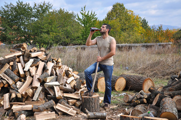 Tired lumberjack get rest and drink beer. Lumberjack drink cold beer to refresh after hard work - Powered by Adobe
