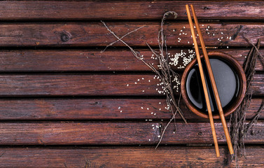 Soy sauce and chopsticks on a wooden table top view
