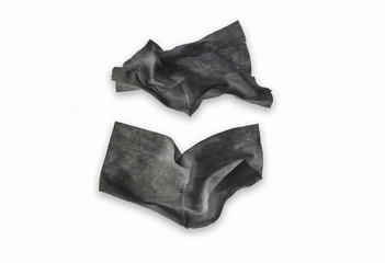 Black crumpled wet napkins isolated on white background