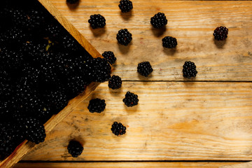 Ripe blackberries in a basket on a rustic wooden table.