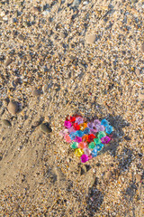 Brightly colored heart of glass pebbles on the sea shore