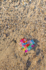 Brightly colored heart of glass pebbles on the sea shore
