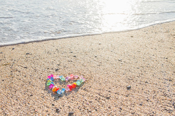 Fototapeta na wymiar Brightly colored heart of glass pebbles on the sea shore