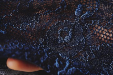 Beautiful delicate openwork dark blue lace in hand - obrazy, fototapety, plakaty