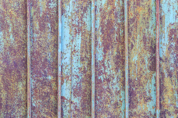 Fragment of the old metal fence painted by blue paint as the background