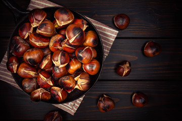 chestnuts in a pan on dark wooden background
