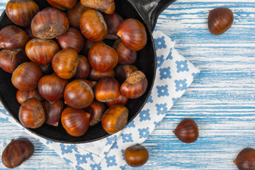 chestnuts in a pan on a wooden background