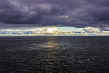 gray heavy clouds over the sea and a strip of light sky