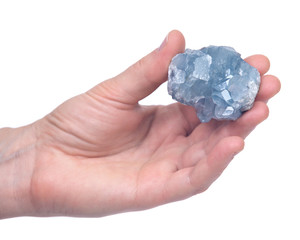 Woman's hand holding blue celestite cluster isolated on white background