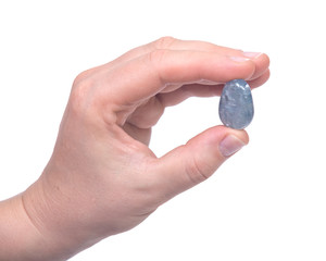 Woman's hand holding blue celestite polished palm stone isolated on white background