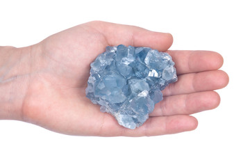 Woman's hand holding blue celestite cluster isolated on white background