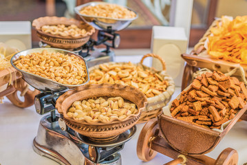 Crackers in a small decorative wooden cart and nuts on the weights
