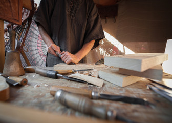 Wood craftsman with various hand tools working.