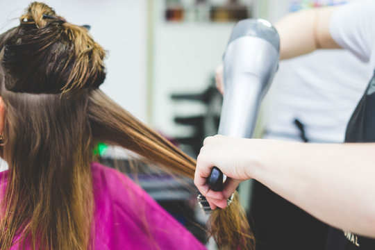 Woman hairdresser making hairstyle in barbershop