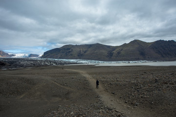 Fototapeta na wymiar hiking in winter, backpacker enjoying panoramic landscape of glacier in Iceland, Skaftafell