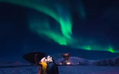Foto op Aluminium The polar arctic Northern lights aurora borealis sky star in Norway Svalbard in Longyearbyen man the moon mountains © bublik_polina