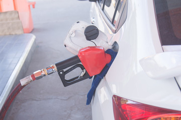 green fuel nozzle to refill fuel in car at gas station.