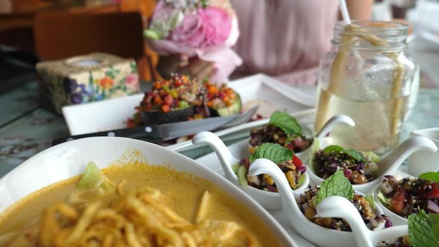 Traditional Thai Food Khao Soi Noodle Curry Soup And Avocado Salad On Table. Closeup. 4K. 