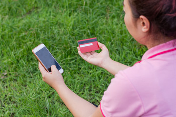 woman hands holding credit card and using cell, smart phone for online shopping