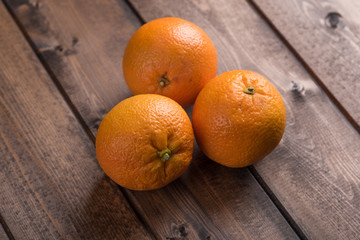 Fresh oranges over a dark wood background