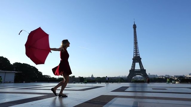 Slow motion of a happy cheerful girl dancing near Eiffel Tower, Paris, France