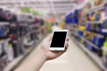 hand holding mobile smart phone with blank monitor screen on Supermarket blur background, business concept