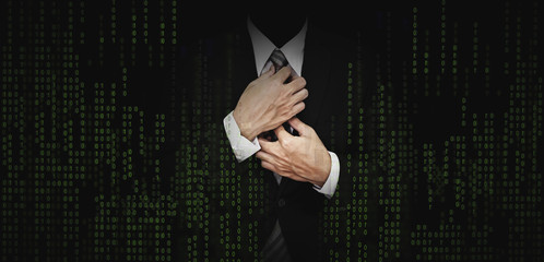 Businessman in black suit with abstract green computer code graphic background. business banking,...
