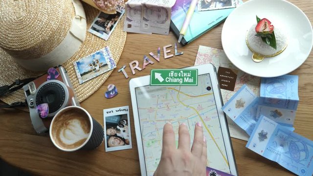 Stylish Hipster Top View of Traveler Vacation Flat Lay On Table. Tablet, Coffee, Map, Hat, Retro Polaroid Camera And Travel Magnets. Closeup. 4K. 