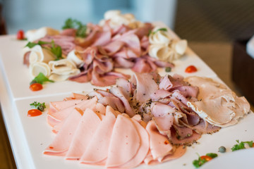 Sliced variety ham, salami on Meat platter Food. Ham Food : delicious salami, pieces of sliced ham,  Cutting sausage and cured meat on a celebrated party event.
