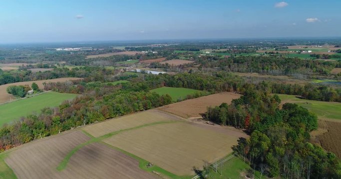 A slow reverse aerial flyover establishing shot of an eastern Ohio farm.  	