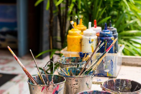 Paint art watercolor brushes. Dirty water color paint box set Oil paints with paint brush, palettein a metal jar at art studio.