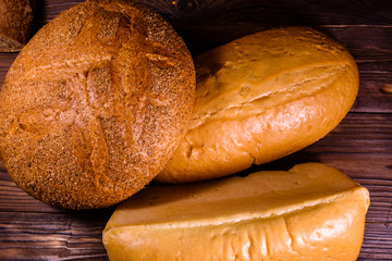 Different loafs of bread on wooden table. Top view
