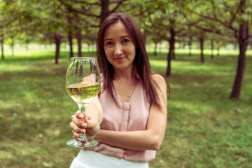 Fototapeta premium Young woman with white wine in the park