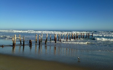 pillars in the ocean, hit by waves