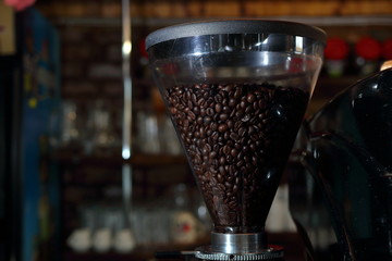 Grains of coffee in the funnel of a coffee grinder coffee machine