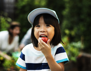 A boy eatting tomato