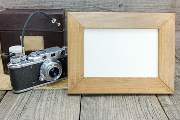 old classic camera and photo frame on gray wooden grunge background