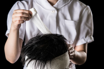 Naklejka premium 包帯を巻く看護師、頭