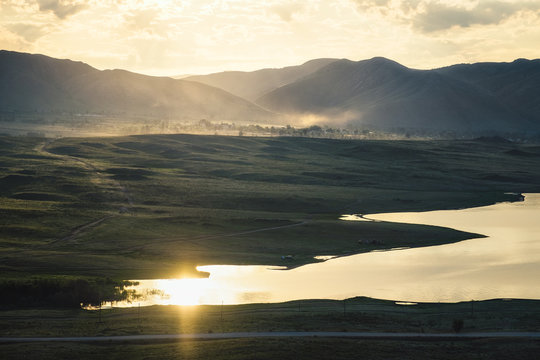 Morning landscape on the lake/Dawn on the lake with the reflection of the sun in the water, Bukhtarma Reservoir, Eastern Kazakhstan