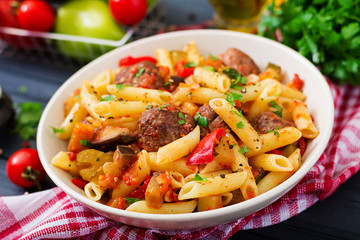 Penne pasta with meatballs in tomato sauce and vegetables in bowl